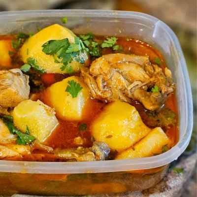Guiso casero de pollo y zapallo servido en recipiente